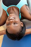 Smiling ethnic woman working out with a pilates ball 