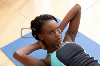 Young ethnic woman in gym clothes working out