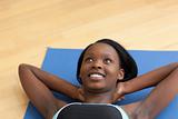 Smiling woman in gym clothes doing sit-ups