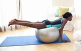 Young Afro-American woman working out with a gym ball