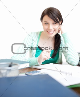 Smiling woman studying sitting at a table in the living-room