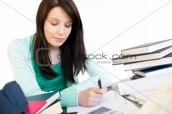 Young woman studying sitting at a table in the living-room
