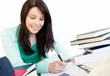 Smiling teen girl studying on a desk