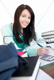 Happy teen girl studying on a desk 