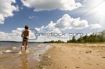young boy running at the beautiful beach