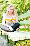 young woman reading book in park