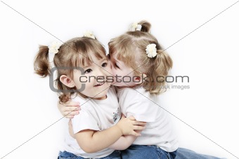 Adorable little twin girls kissing isolated on white background 