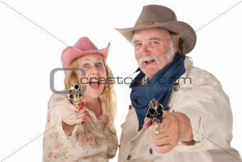 Couple in western wear pointing pistols 