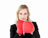 A portrait of a confident businesswoman with boxing gloves