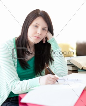 Tired attractive student sleeping while doing her homework