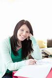 Smiling brunette student doing her homework