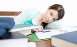 Attractive tired woman studying on a table