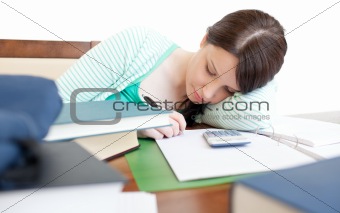 Young tired woman studying on a table 