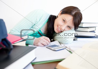 Smiling student doing her homework on a desk