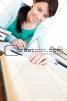 Cheerful student doing her homework on a desk 