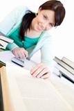 Positive student doing her homework on a desk