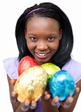 Smiling ethnic woman showing Easter eggs 