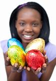 Happy ethnic woman showing Easter eggs 