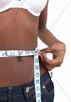 Ethnic woman measuring her waist with a tape measure