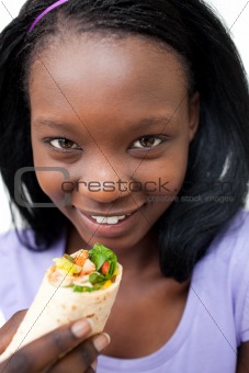 Charming young woman eating a wrap 