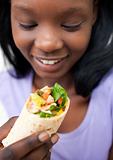 Afro-american young woman eating a wrap