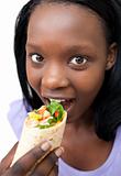 Young woman eating a wrap 