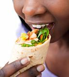 Close-up of a young woman eating a wrap