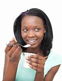 Happy young woman eating a yogurt 