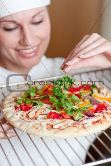Charming female chef preparing a pizza