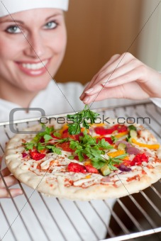 Young female chef preparing a pizza