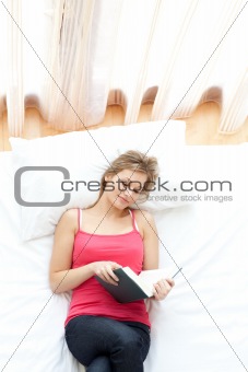 Relaxed woman reading on her bed