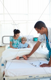 Smiling doctor examining little girl's feet