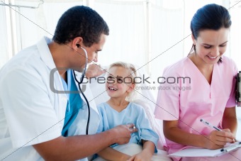 Male doctor and female nurse examining a child patient