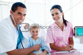 A doctor checking the pulse on a smiling little girl 