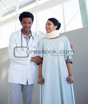 A doctor helping a patient with neck brace and on crutches