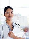 Smiling female doctor holding a medical clipboard 