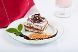 Sweet chocolate dessert with nuts and chocolate on white plate