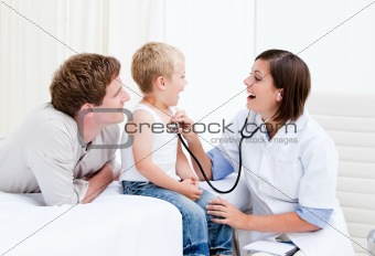 Portrait of beautiful female doctor examining a little boy with his father at the hospital