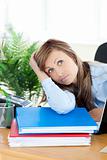 Unhappy young businesswoman sitting at her desk