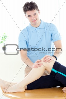 Young physical therapist giving a leg massage