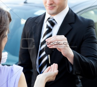 Close-up of a salesman giving car's key