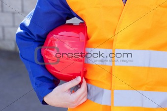 Close-up of a caucasian man holding a red hardhat against a white background