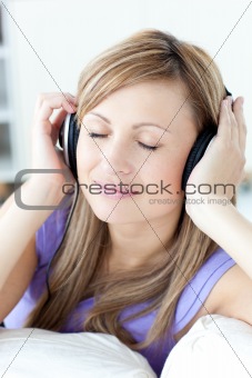 Portrait of a cheerful woman listening music in the kitchen 