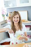 Portrait of a joyful woman preparing a cake in the kitchen 
