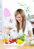 Cheerful woman preparing a healthy meal in the kitchen