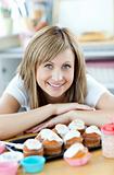 Delighted woman eating cakes in the kitchen 