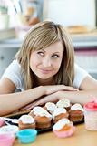 Delighted woman wants to eat cakes in the kitchen