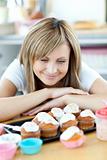 Delighted woman looking at cakes in the kitchen 