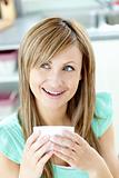 Delighted woman drinking a coffee at home