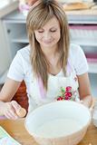 Portrait of a happy woman preparing a cake in the kitchen